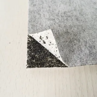 Sandwich nonwoven with an outer layer lifted to show the carbon interlayer