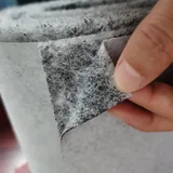 Sandwich nonwoven layer close-up with an outer layer peeled back